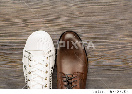 Men's classic brown shoes and white sneakers on a Men's classic brown shoes and white sneakers on a 63488202