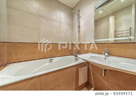 Small beige tile bathroom with bath tube 63494571