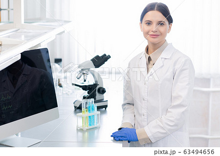 Young successful female scientist or pharmacist in gloves and whitecoat Young successful female scientist or pharmacist in gloves and whitecoat 63494656