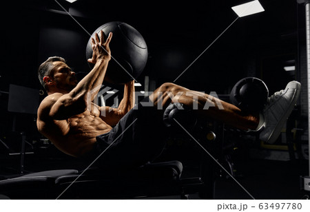 Man building core muscles with ball. 63497780