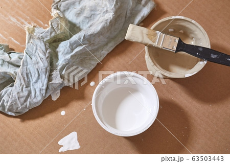 Paint brush on a can of white wall paint 63503443