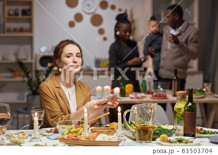 Woman using phone at the party Woman using phone at the party 63503704
