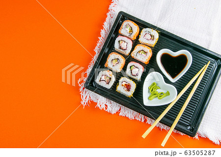 Black plate with sushi, filled with rolls of 63505287