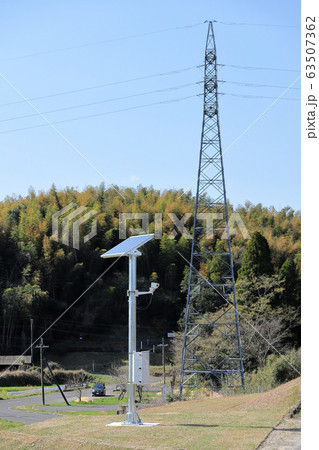 監視カメラ・防犯カメラが付いている小さなソーラーパネルと送電線 63507362