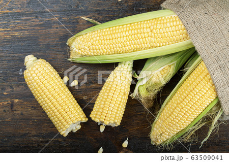 Fresh corn on cobs on wooden table. 63509041
