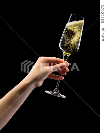 Woman hand holding glass of sparkling champagne isolated on black. 63510679