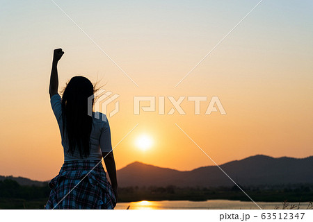Soft focus of woman with fist in the air during sunset Soft focus of woman with fist in the air during sunset 63512347