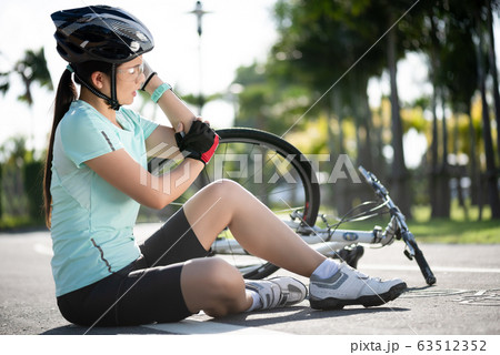 Bike injuries. Young woman cyclist fell fell off Bike injuries. Young woman cyclist fell fell off 63512352