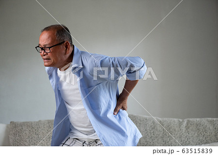 Asian old man sitting on sofa and having a back pain Asian old man sitting on sofa and having a back pain 63515839