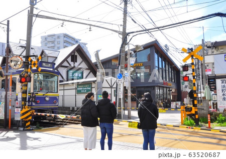 神奈川県藤沢市　江ノ電江ノ島駅前の踏切で電車の通過を待つ人 63520687