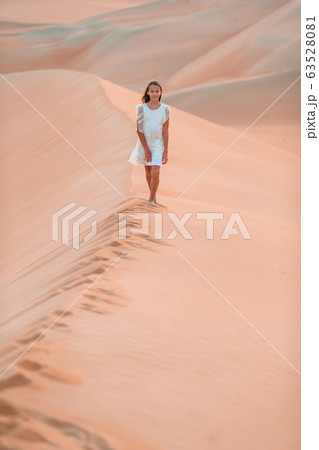 Girl among dunes in desert in United Arab Emirates 63528081