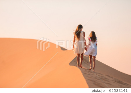 Girls among dunes in big desert in Emirates Girls among dunes in big desert in Emirates 63528141