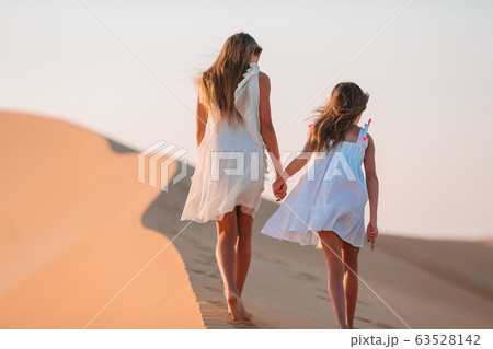 Girls among dunes in big desert in Emirates 63528142