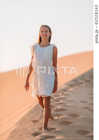 Girl among dunes in desert in United Arab Emirates 63528143