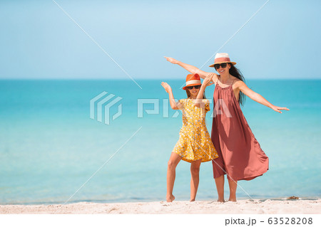 Beautiful mother and daughter on the beach Beautiful mother and daughter on the beach 63528208