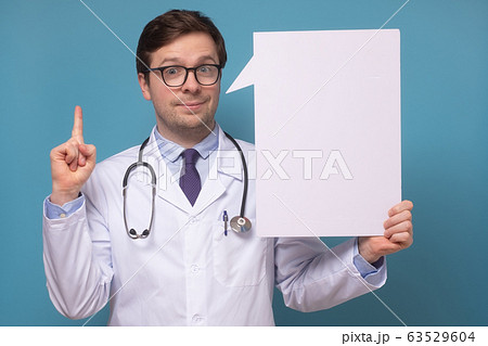 Young caucasian doctor pointing up showing on 63529604