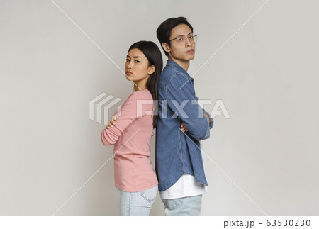 Unhappy asian man and woman staying back to back Unhappy asian man and woman staying back to back 63530230