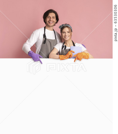 Smiling Couple Wearing Cleaning Gloves And Pointing At White Advertisement Board 63530306