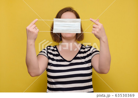 Anonym caucasian woman shows in hands medical mask Anonym caucasian woman shows in hands medical mask 63530369