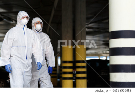 Men in virus protective suits patrol the city while quarantine 63530693
