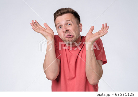 Clueless, funny looking young man holding arms out 63531128