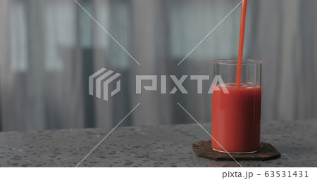 pour tomato juice into glass on concrete surface with copy space 63531431