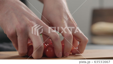 closeup man hands take cherry tomatoes from olive board closeup man hands take cherry tomatoes from olive board 63531667