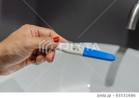 Woman holding a pregnancy test 63531686