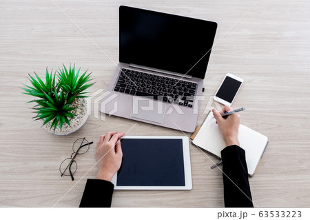 The woman is working with various office gadgets The woman is working with various office gadgets 63533223
