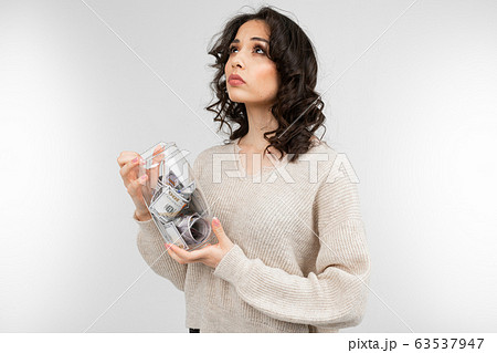 girl dreams of spending her money from a piggy bank on a white background 63537947