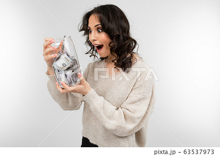 girl dreams of spending her money from a piggy bank on a white background 63537973