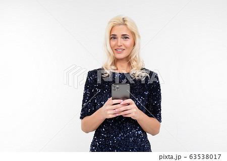 close-up of a beautiful charming woman in a shiny dress sitting on the phone on a white background close-up of a beautiful charming woman in a shiny dress sitting on the phone on a white background 63538017