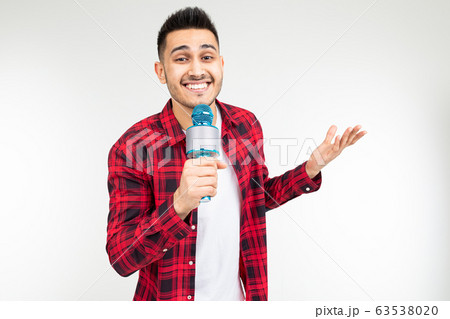 performer guy singer in a shirt with a microphone in his hands on a white background performer guy singer in a shirt with a microphone in his hands on a white background 63538020