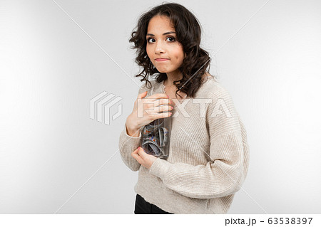 girl dreams of spending her money from a piggy bank on a white background girl dreams of spending her money from a piggy bank on a white background 63538397