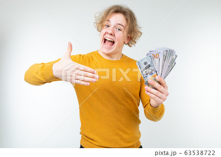 happy blond guy won money on a white background 63538722