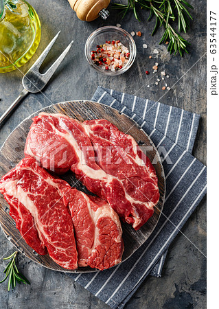 Raw beef steak on dark gray background 63544177