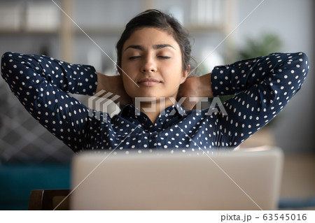 Head shot peaceful Indian girl leaning back in chair 63545016