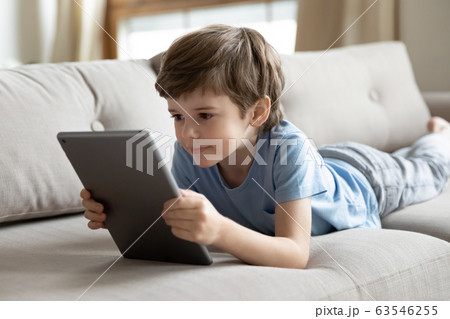 Smart little boy using modern tablet at home 63546255