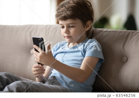 Little preschooler boy using smartphone at home Little preschooler boy using smartphone at home 63546256