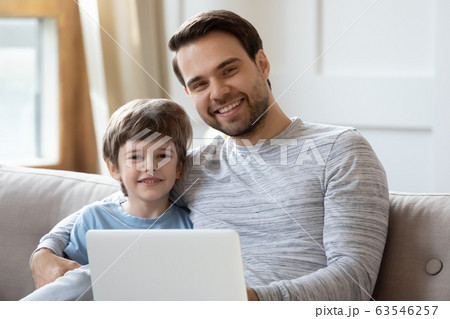 Portrait of young dad and little son using laptop Portrait of young dad and little son using laptop 63546257