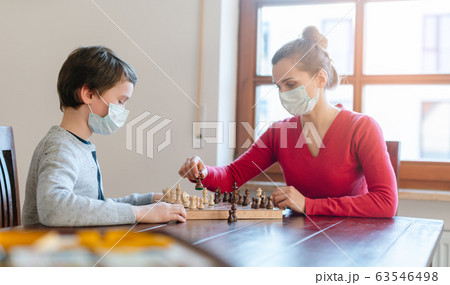 Mother and son playing chess to kill some time during curfew in crises Mother and son playing chess to kill some time during curfew in crises 63546498