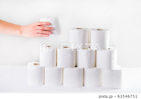 A male hand takes a roll of toilet paper from a 63546751