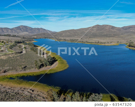 Aerial view of Otay Lake Reservoir with blue sky and mountain 63547320