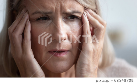 Unhealthy mature retired woman suffering from strong sudden headache. 63548709