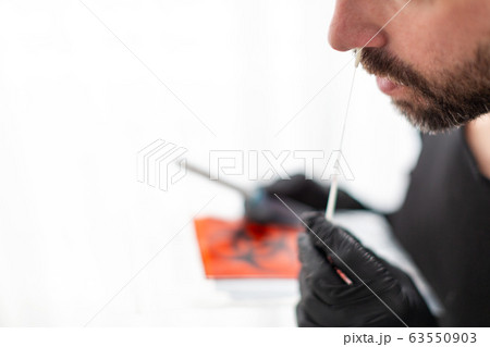 Man makes with a cotton swab a nasal swab test 63550903