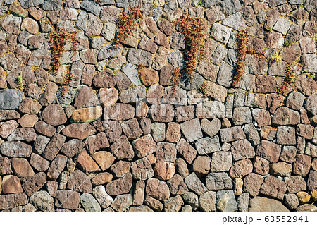 Heart shape stone and wall near Megane-bashi spectacles bridge in Nagasaki, Japan 63552941