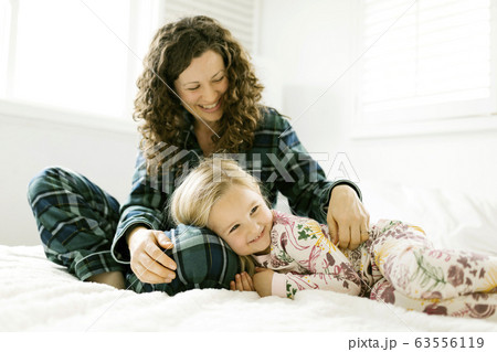 Mother and daughter hugging on bed Mother and daughter hugging on bed 63556119