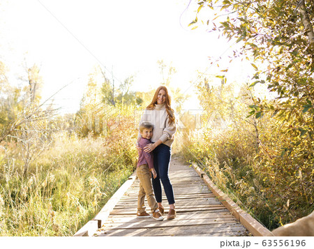 Mother and son embracing on forest boardwalk Mother and son embracing on forest boardwalk 63556196