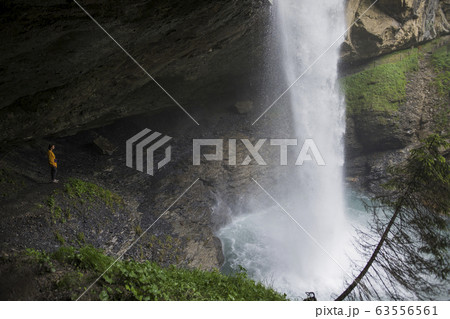 Woman in jacket by waterfall Woman in jacket by waterfall 63556561