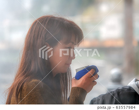 温泉街　飲泉を楽しむ女性　ポートレート 63557984